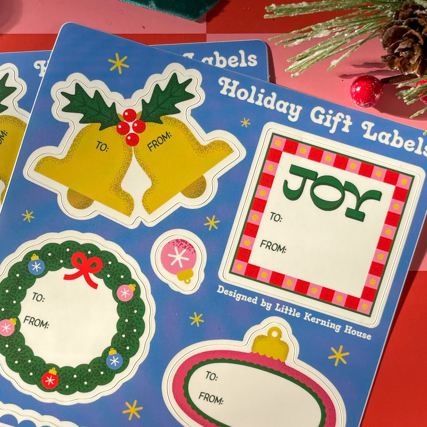Set of holiday gift labels with bells, wreaths, and 'JOY' design on a colorful background.