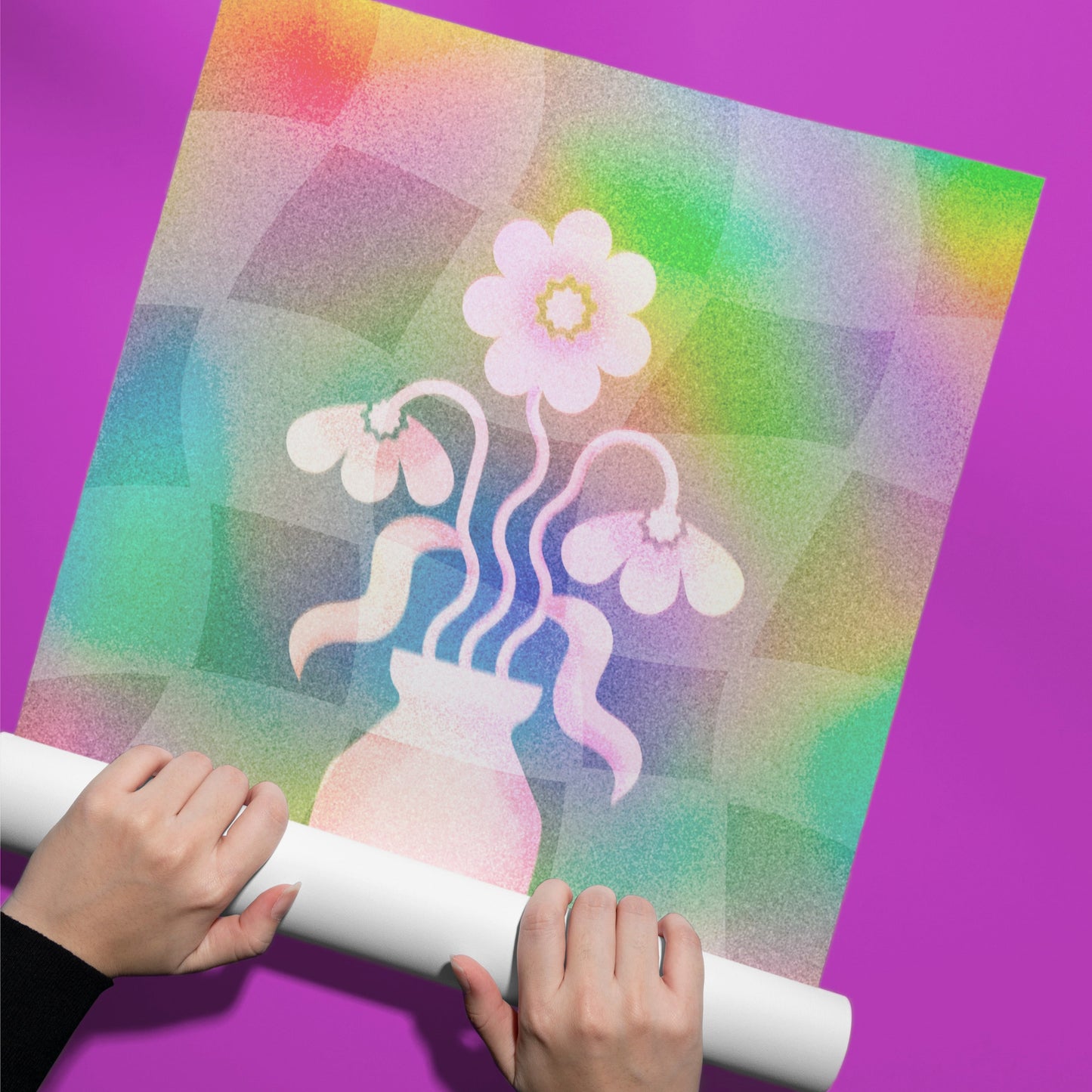 Colorful paper with a flower design held by hands against a purple background