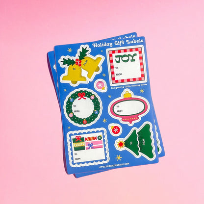 Set of holiday-themed gift labels on a pink background