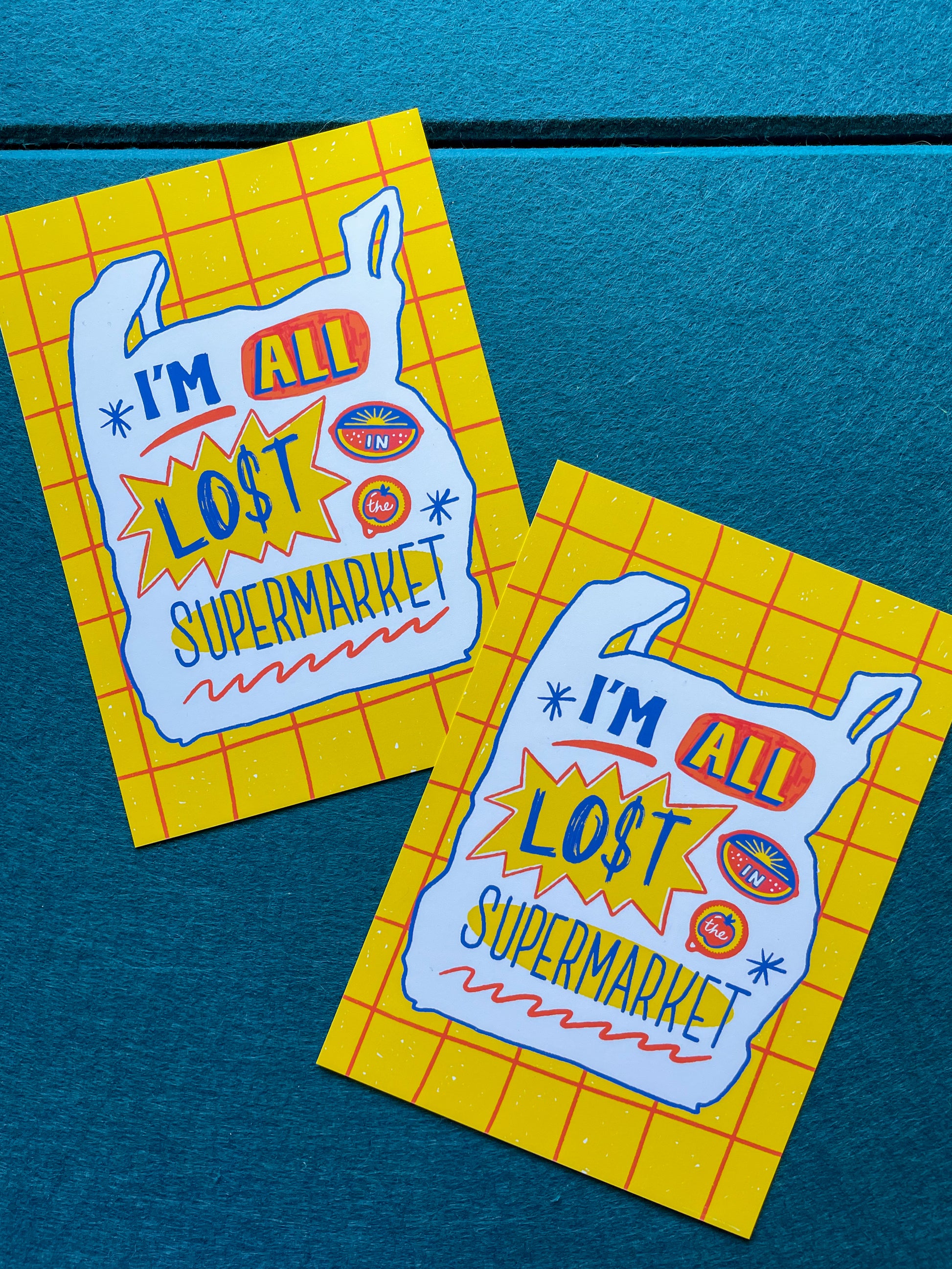 Two 'I'm All Lost Supermarket' 5x7" prints on a blue felt  background