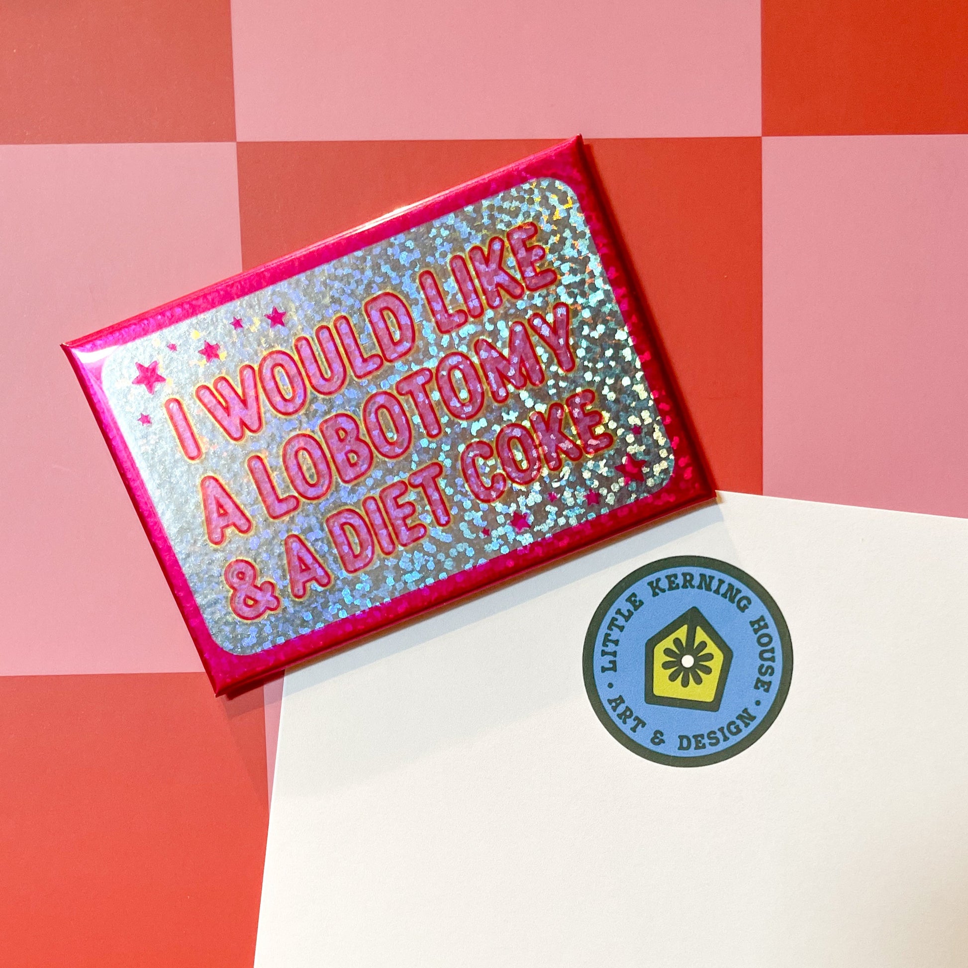 Glittery pink rectangle magnet with text 'I would like a lobotomy & a diet coke' on pink and red checkered background holding up a note