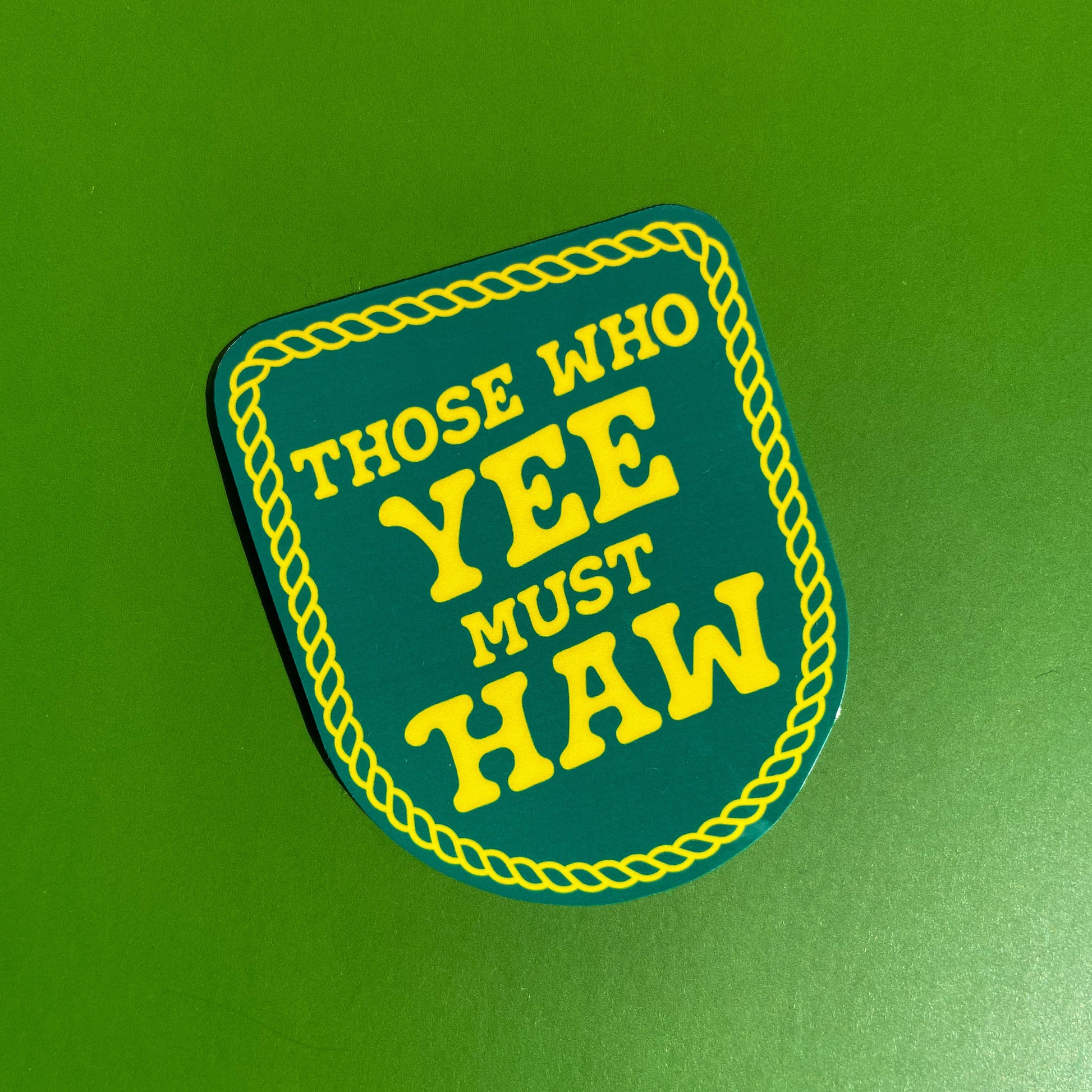 Sticker designed to look like a patch  with 'Those Who Yee Must Haw' text on a green background