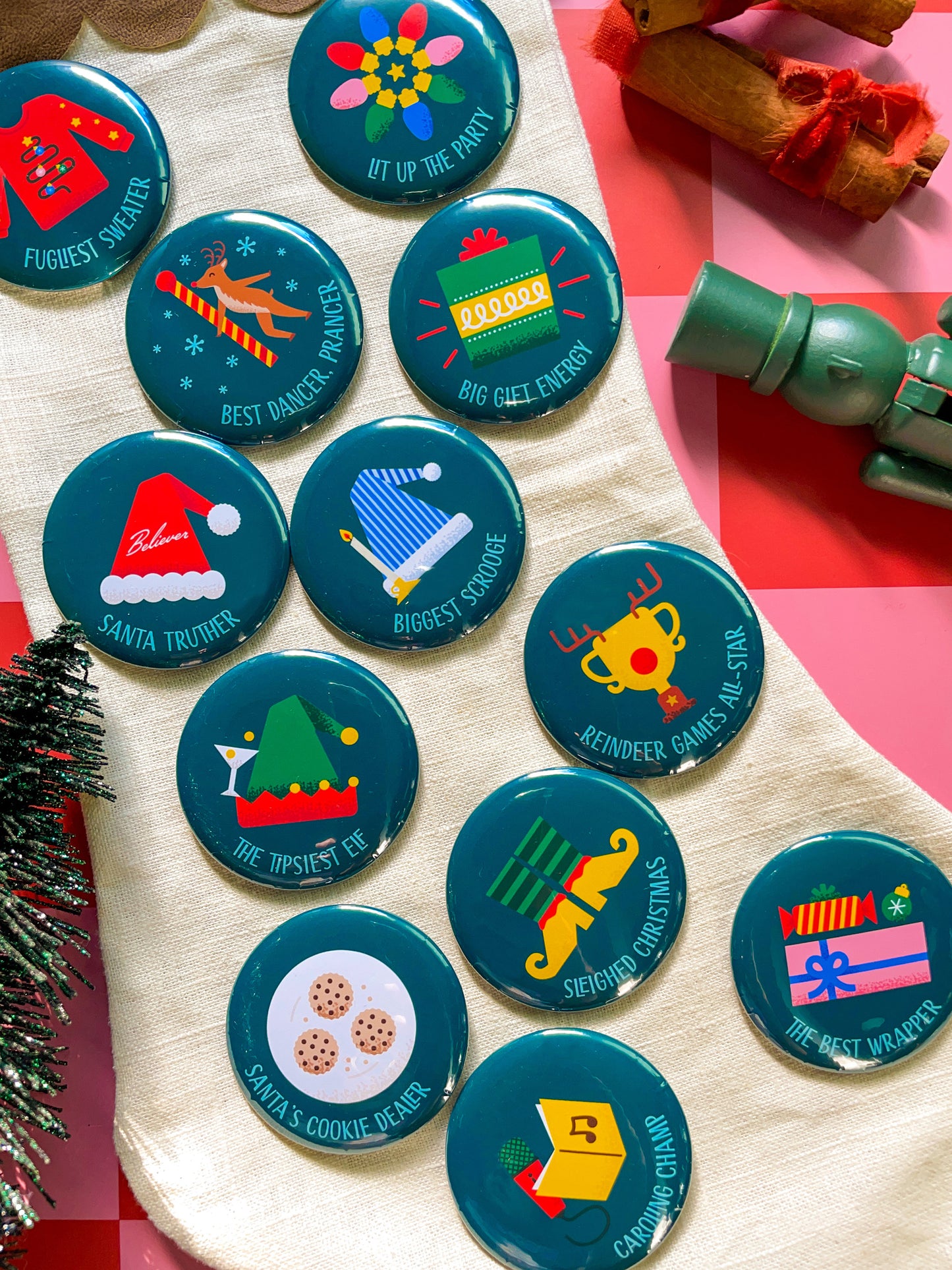 Collection of Christmas-themed buttons on a fabric background with festive decor.