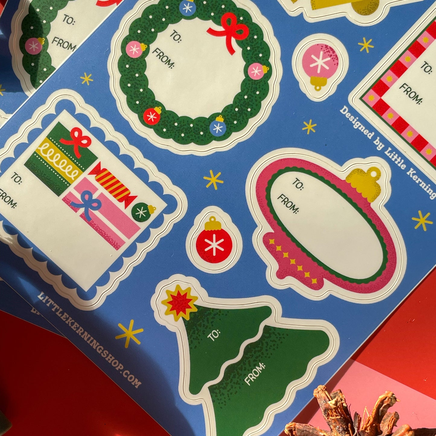 Set of Christmas-themed gift tags on a colorful background with a pine cone.