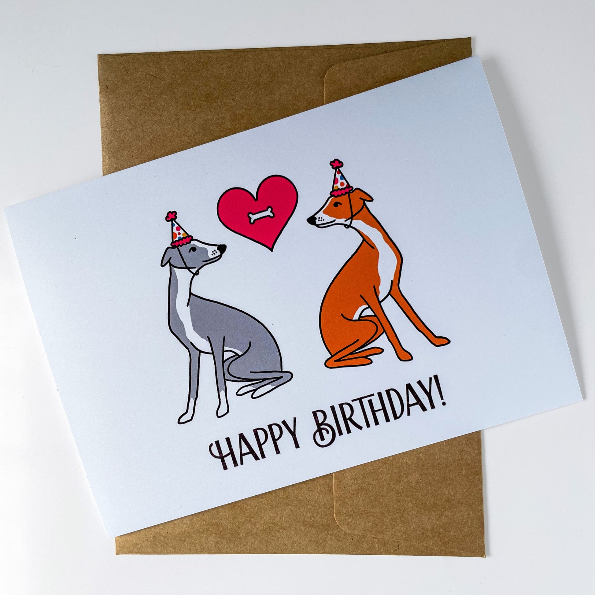 Birthday card with two dogs and a heart, featuring 'Happy Birthday!' text, on a white background.