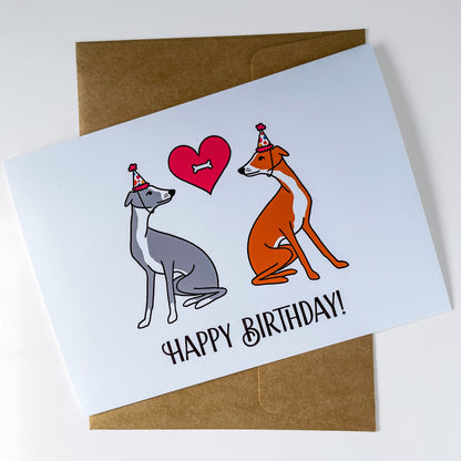 Birthday card with two dogs and a heart, featuring 'Happy Birthday!' text, on a white background.