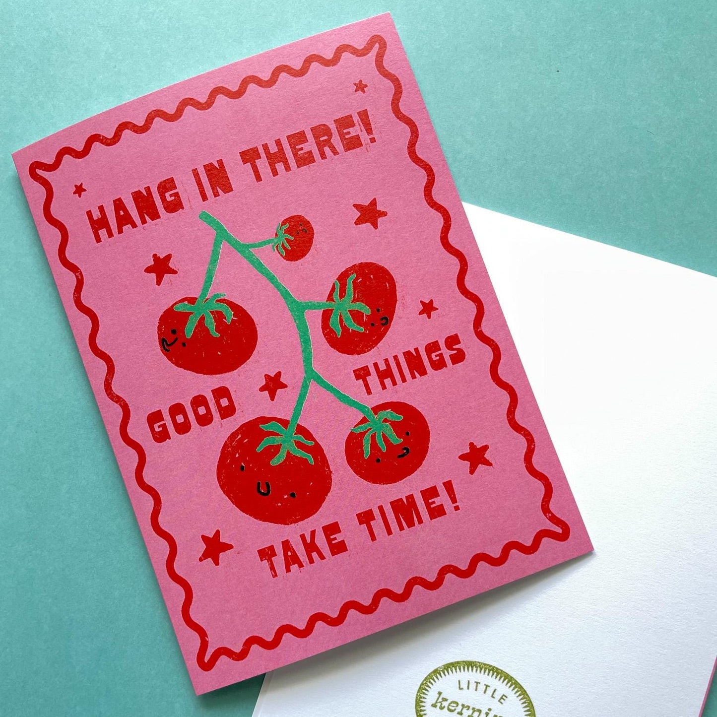 Pink card with tomato illustration and text on a teal background